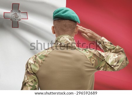 Dark-skinned soldier in hat facing national flag series - Malta