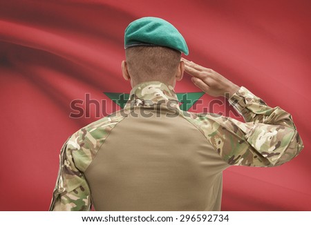 Dark-skinned soldier in hat facing national flag series - Morocco