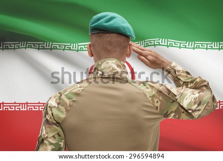 Dark-skinned soldier in hat facing national flag series - Iran