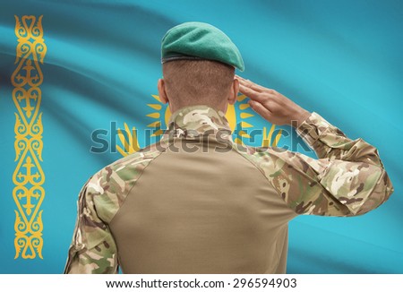 Dark-skinned soldier in hat facing national flag series - Kazakhstan