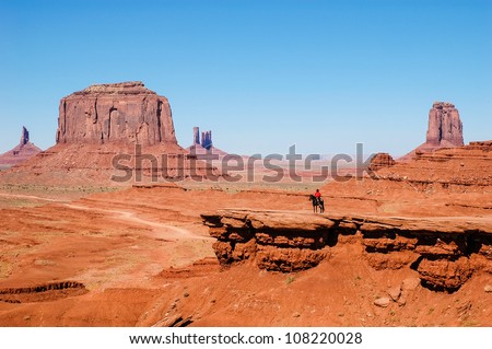 an Indian on a horse in front of a red rock formations in Monument Valley ein Indianer auf einem Pferd vor einer Rote Felsformationen im Monument Valley