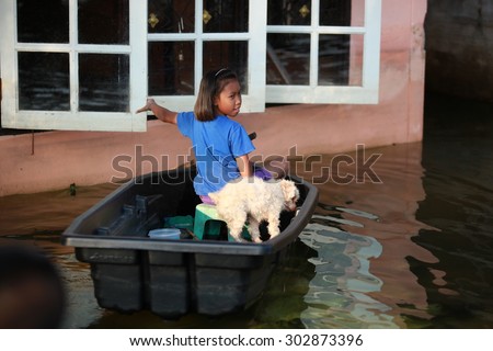 Bangkok,Thailand - October 2011 : Girl and dog on boat , Huge flood disaster in Thailand