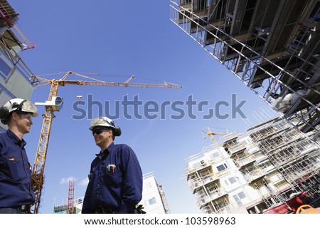 construction engineers, workers, with building site in background, wide-angle perspective