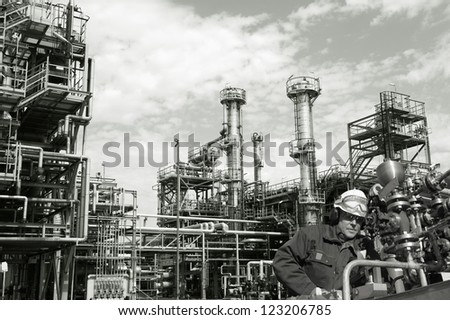 oil-worker, engineer, with pipelines machinery, large refinery in background, duplex toning concept