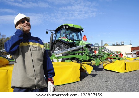 modern farmer with tractor and large mowers