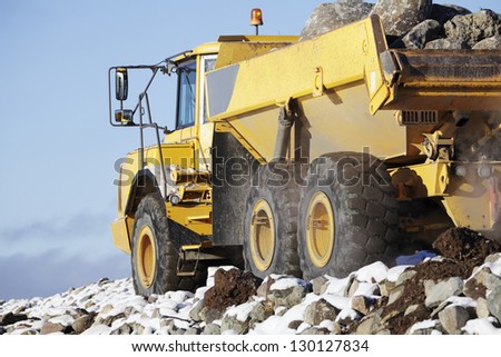 truck driving, snow and rocks, close-ups view