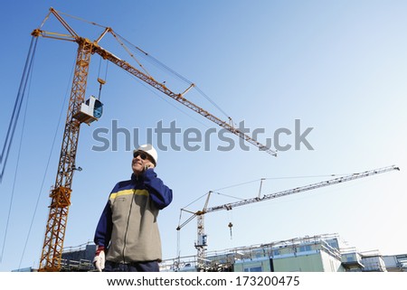 building worker with cranes and scaffolding in the background