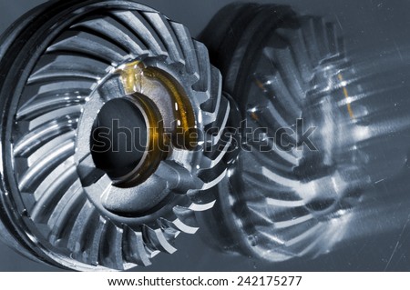 cogwheels with oil slicks mirrored in titanium
