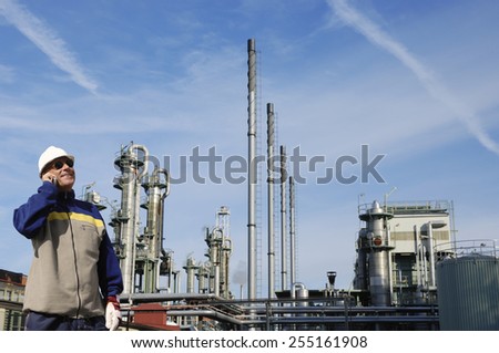 oil worker in front of large oil and gas refinery
