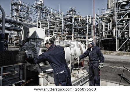 oil and gas workers with machinery inside large refinery