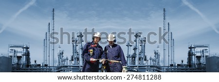oil and gas engineers with large refinery in background, panoramic view