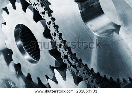 cogwheels and gears powered by large chains, blue toning concept