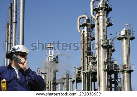 oil and gas worker with refinery towers in background