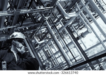 refinery worker with giant pipelines construction, selenium toning.
