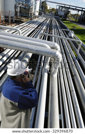 oil worker pointing out on long stretched pipelines inside refinery industry