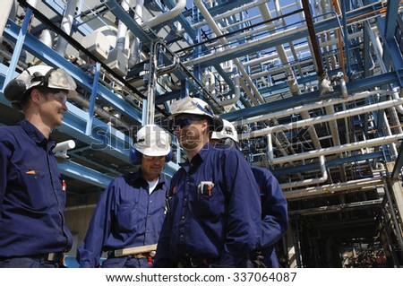 oil and gas workers inside large pipelines constructions, chemical refinery industry