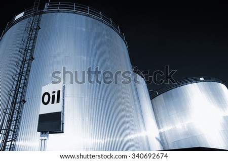 fuel and oil storage tanks at night, large info sign, oil