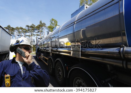 refinery worker filling large fuel-truck inside refinery, oil and gas transportation