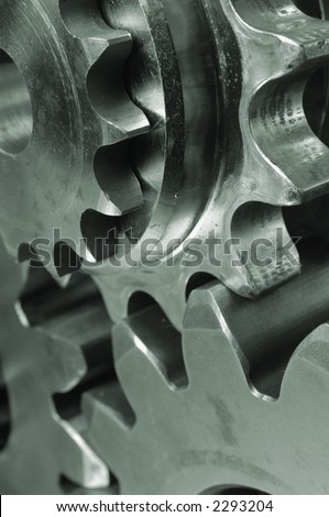close-up of three gears, cogwheels connecting in greenish cast