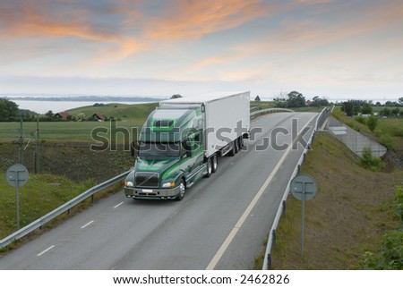 large truck, lorry driving on countryroad in early morning