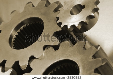 three gears connecting in a sepia colored cast