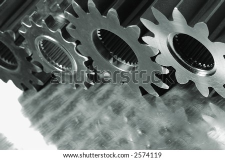 three gears in a row, standing on brushed aluminum