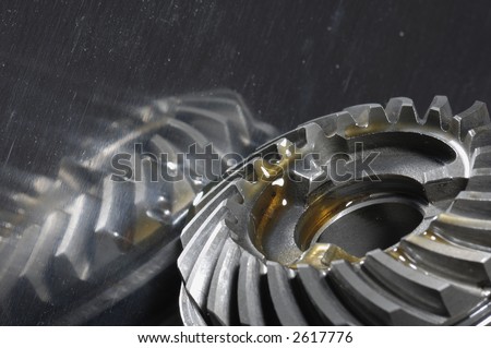 gearbox gears in lubricant-oil against shiny titanium