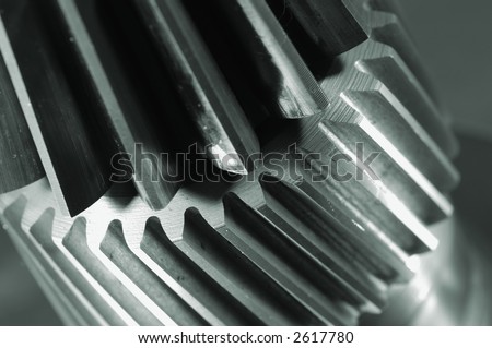 extreme close-ups of two gears connecting in a metallic greenish cast
