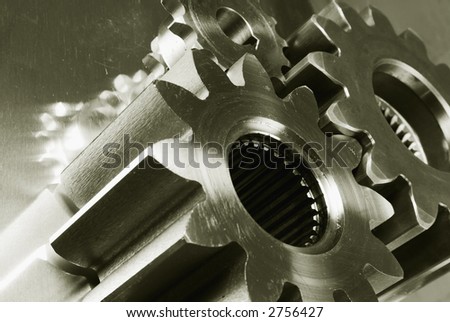 three gears connecting against shiny titanium ( duplex )