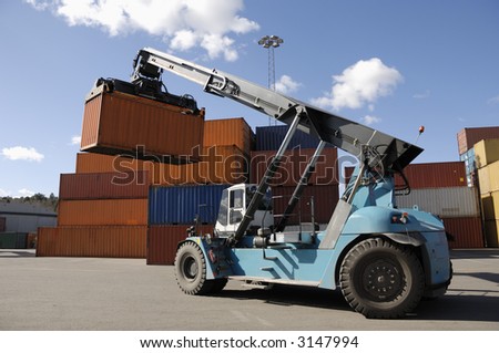 giant forklift-truck stacking containers in commercial port