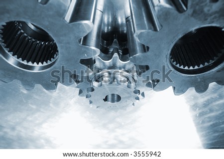 large and small gears in machinery all in a blue metallic toning