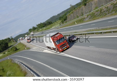 clean red truck driving on highway with country scenery in background