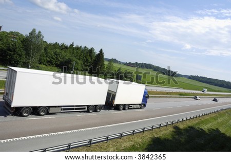 large clean white truck driving into distance, shot from behind and from above