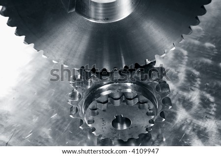 large and small industrial gears against brushed aluminum