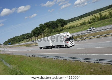 clean white truck on highway with field and forrest in background
