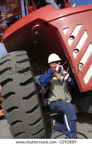 engineer, auto-mechanic working on large truck, forklift