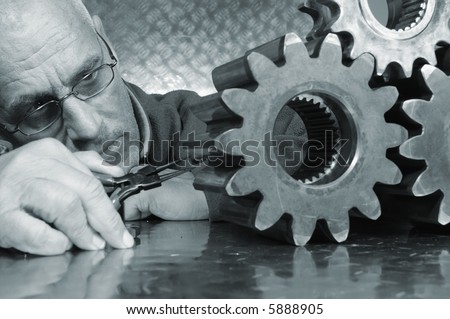 engineer studying three gears and in a blue toning idea