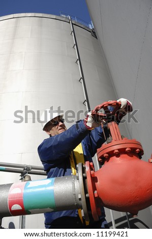 industry worker turning on pipeline and fuel pump inside oil industry