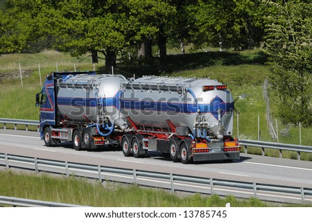 large fuel truck, fuel tanker driving on freeway.
