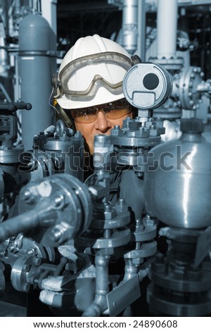 chemical worker behind large fuel pump machinery, blue toning concept