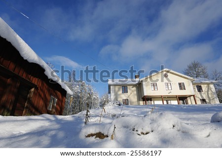 old manor house in winter with snow and old red barn. typical swedish winter scene.