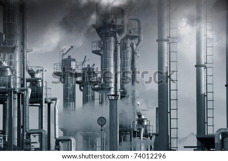 dark toxic clouds and smog over petrochemical oil and gas installation, blue toning concept