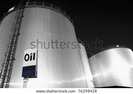 industrial fuel and oil storage tanks, towers, large commercial oi-sign in foreground, silver duplex toning idea