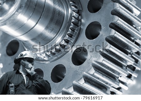worker, engineer, with large gears machinery in background, blue toning concept, focal-point, on engineer