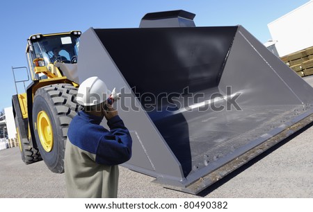 worker and giant bulldozer, digger, construction and excavating machinery
