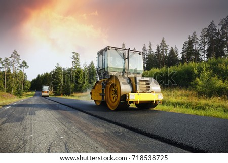 steamrollers paving a newly laid asphalt on a country road, road-works