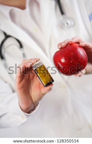 Apple vs. drugs in doctor\'s hands. Healthy choice concept