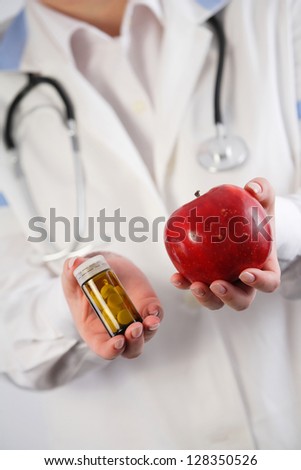 Apple vs. drugs in doctor\'s hands. Healthy choice concept