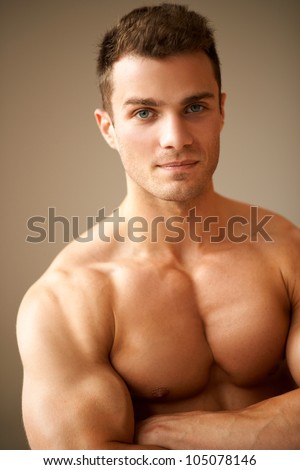 Close up of sporty man with muscular arms crossed on brown background - stock-photo-close-up-of-sporty-man-with-muscular-arms-crossed-on-brown-background-105078146