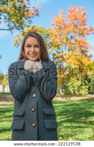 Smiling Pretty Woman Chilling in Gray Coat Looking at Camera. Captured Outdoor. Isolated on Nature View.